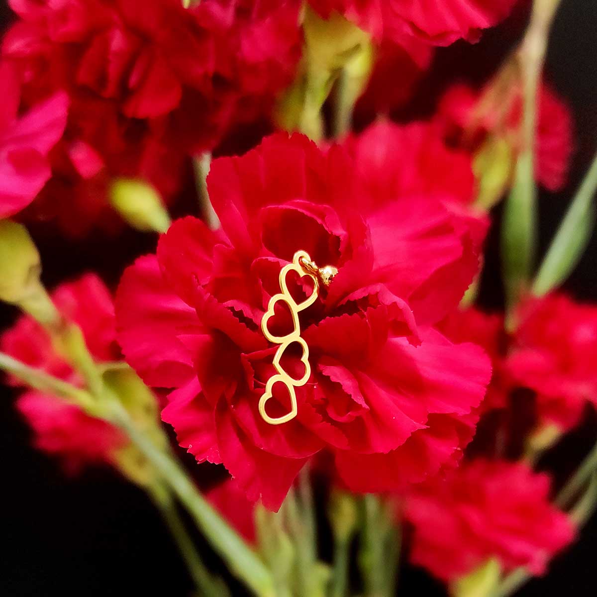 Damskie kolczyki sztyft celebrytka serca wykonana ze srebra 925 pozłoconego położone na kwiatku