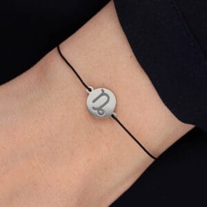 Bransoletka dla Koziorożca na czarnym sznurku z celebrytką. Bransoletka srebrna na czarnym sznurku na ręce