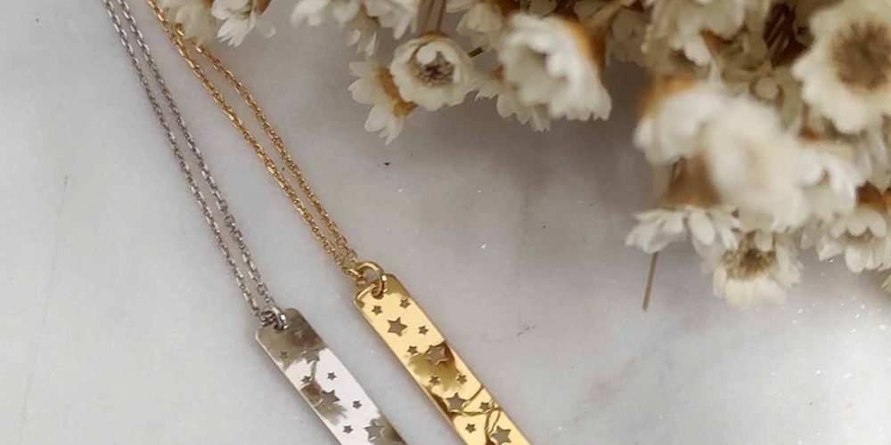 Damskie naszyjniki srebrne i pozłacane celebrytka gwiazdki STARRY Dwa naszyjniki celebrytka prostokątne z wyciętymi gwiazdkami w formie srebrnej i pozłacanej. Naszyjniki leżą na marmurowej podstawce