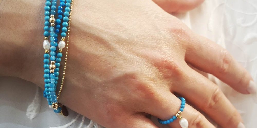 Zestaw bransoletek i pierścionka elastycznego wykonany z turkusów, pereł i kuleczek srebra pozłacanego Zestaw bransoletek i pierścionka elastycznego założony na rękę, wykonany z turkusów, naturalnych pereł i kuleczek srebra pozłacanego
